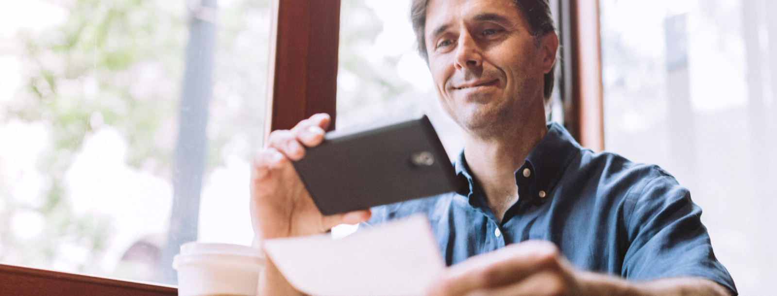 Man snapping photo of check for deposit