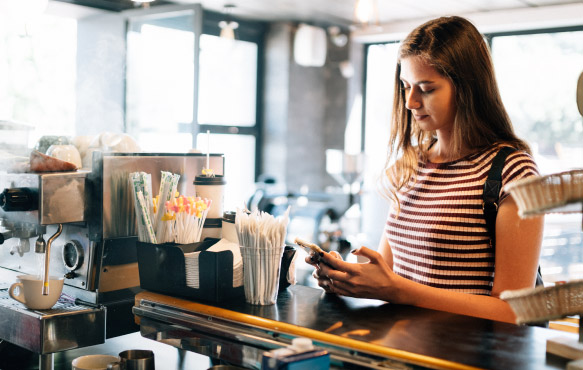 Woman paying for items at cafe counter